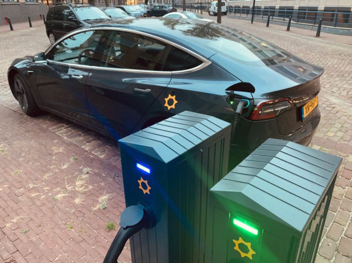 Tesla van We Drive Solar aan een laadpaal.
